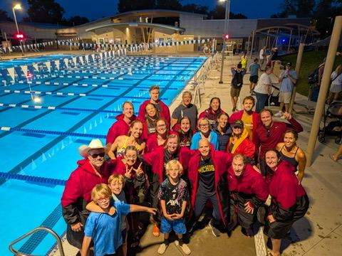 The Louisvillains gathered on the pool deck at night in team parkas
